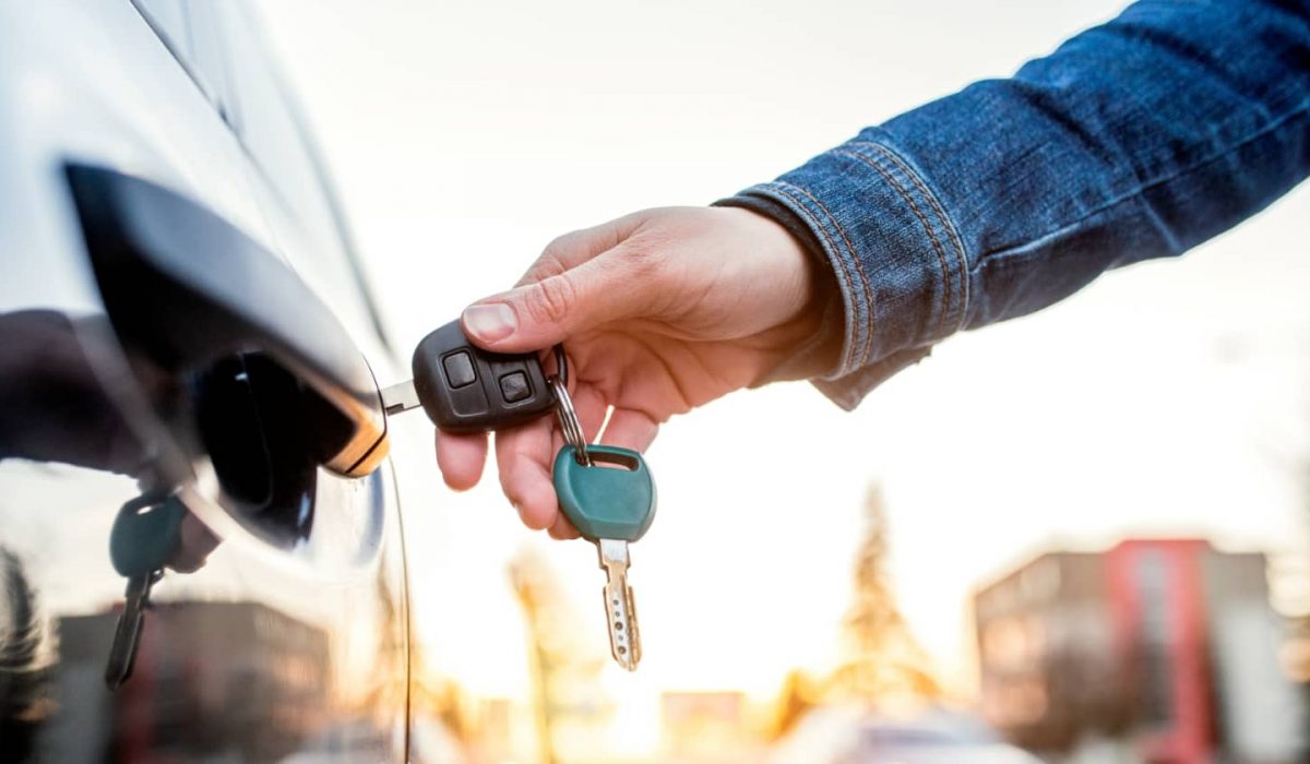 An image of someone opening a car door with a set of replacement keys